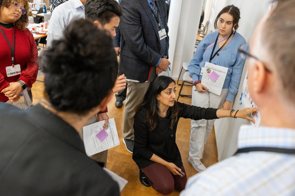 Woman in a meeting pointing at a whiteboard