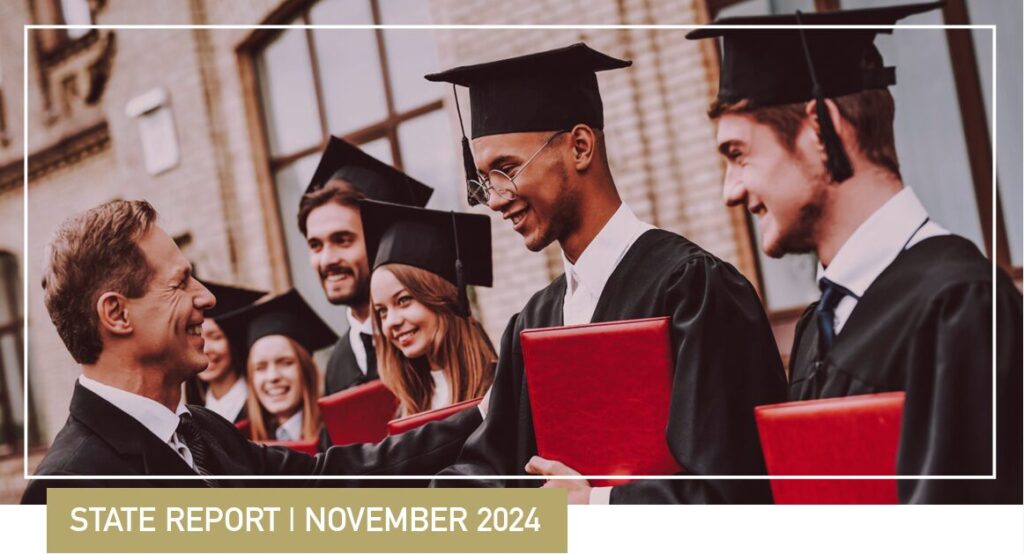 Students in a line with their graduation caps and gowns and diplomas.