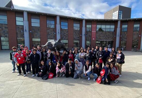 Central Washington University students in front of a statue of their wildcat mascot.