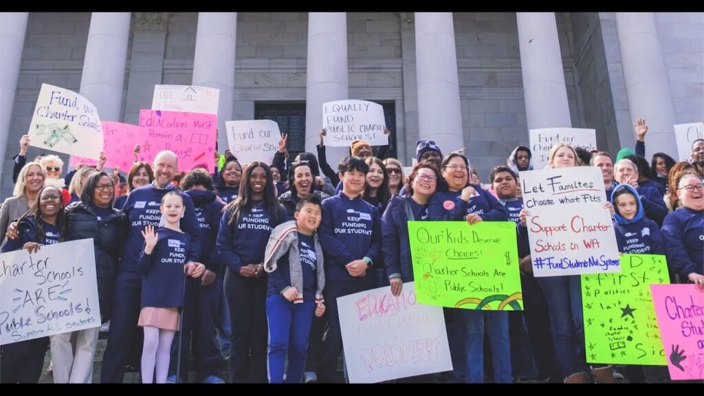 Diverse group of different ages standing together with protest boards.
